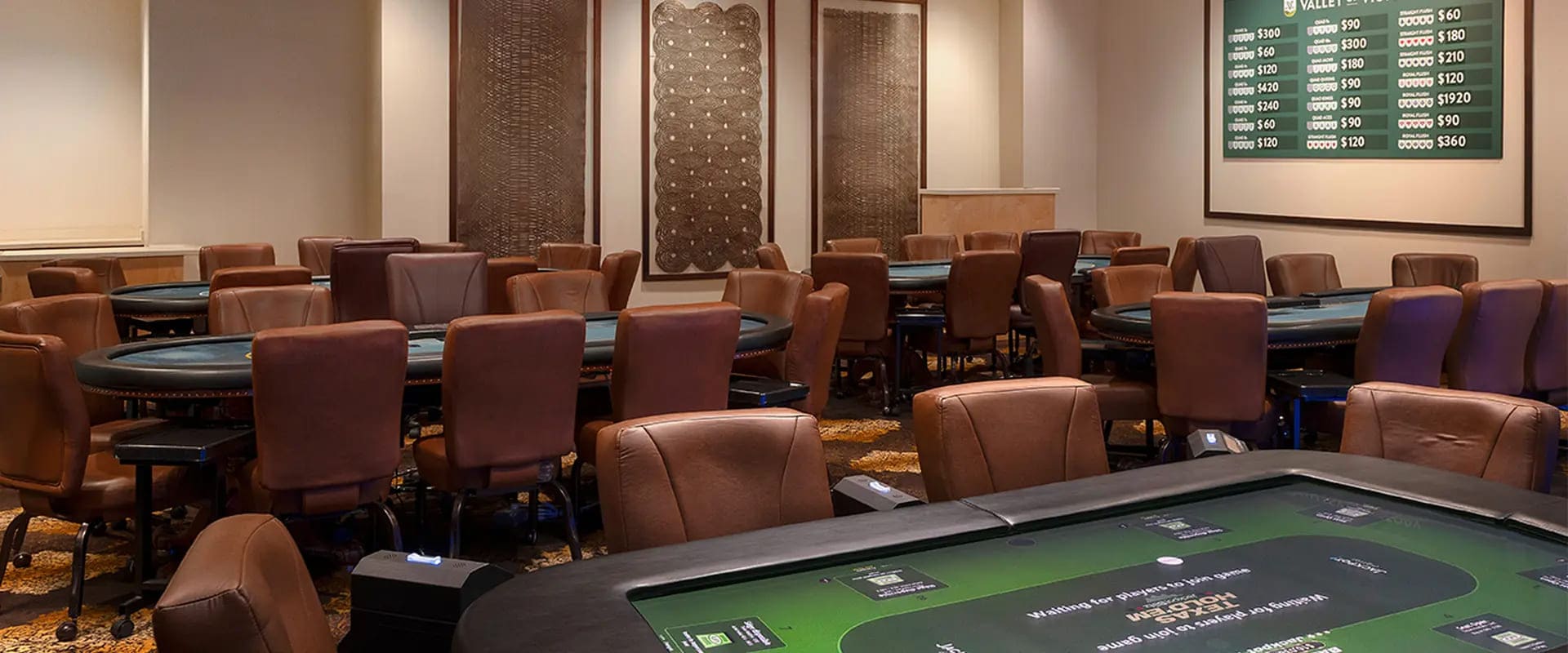 Szeroka sala pokerowa gotowa na gości z zielonymi stołami i krzesłami
